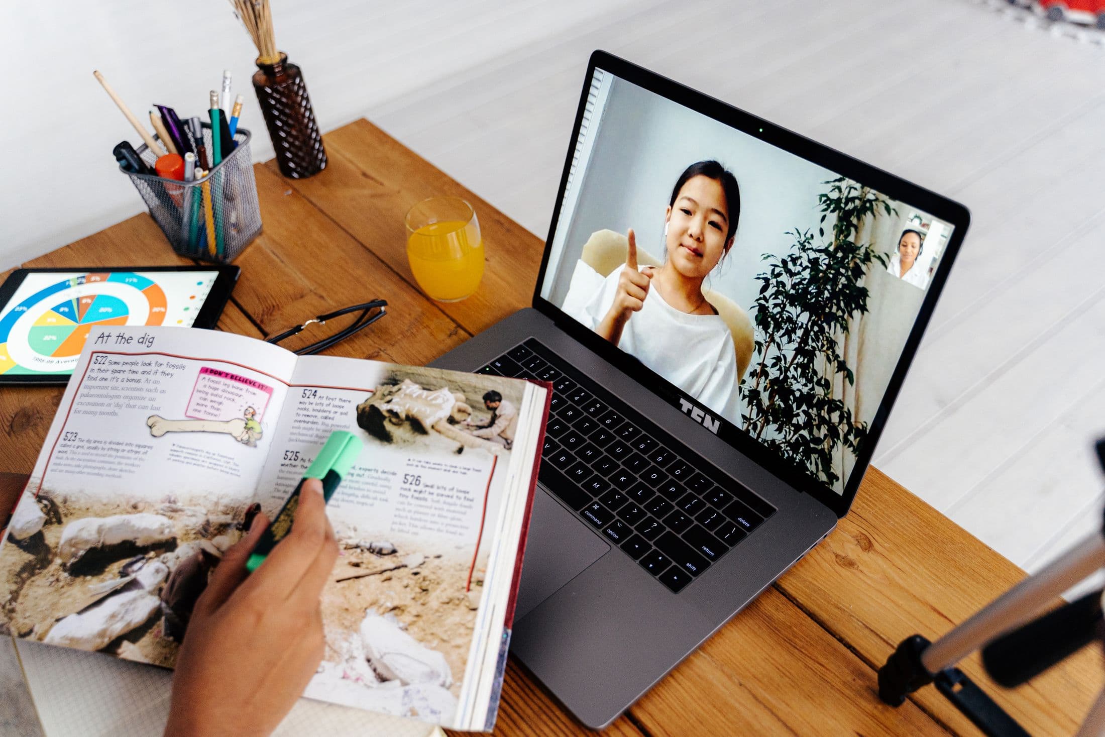 Online tutoring lesson with workbook, tablet, and laptop