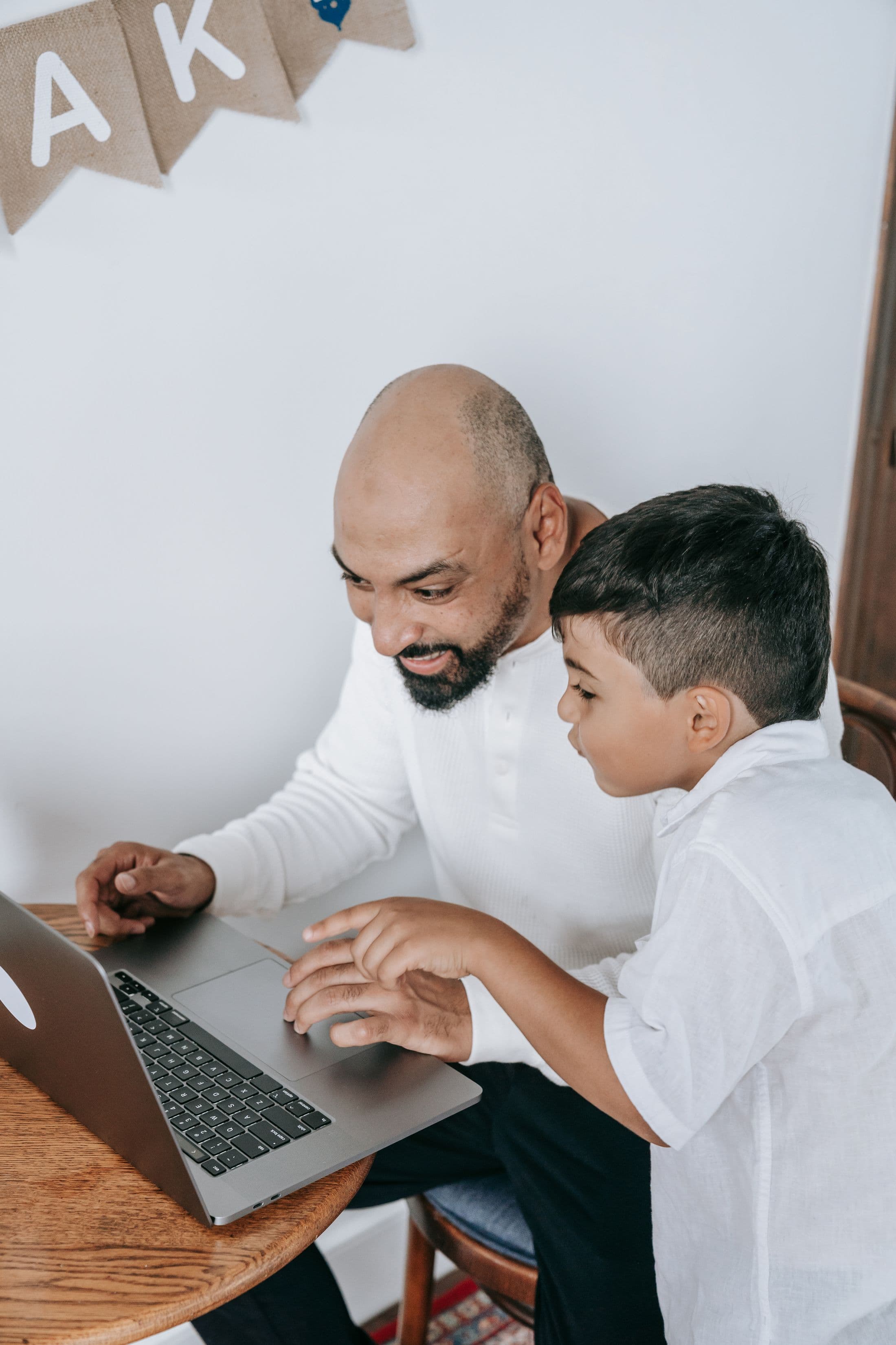 Parent and child reviewing online learning on a laptop